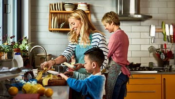 cheerful lesbian couple preparing food with adopted son in kitchen, learning, sharing, encouragement