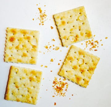 four saltine and crumbs on white