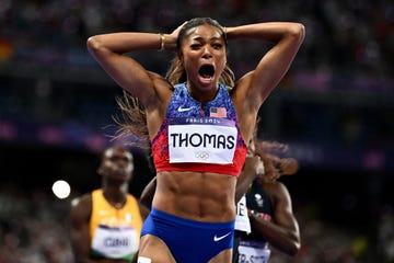 gabby thomas raises her hands up and celebrates after winning in paris 2024 olympics