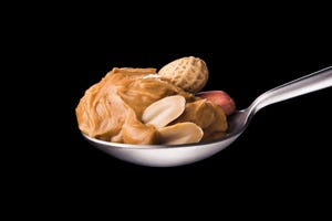 peanut butter on a spoon isolated on a black background