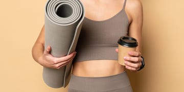 woman with yoga mat and coffee cup