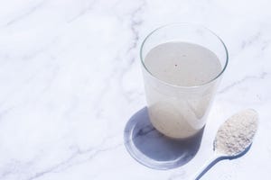 a glass of water soluble psyllium husk dietary fiber supplement put on white marble table in the morning sunlight