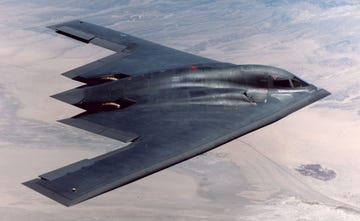 stealth bomber flying over a desert landscape