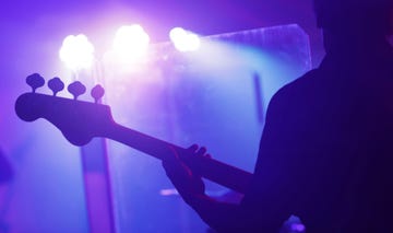 a person holding a bass guitar on stage