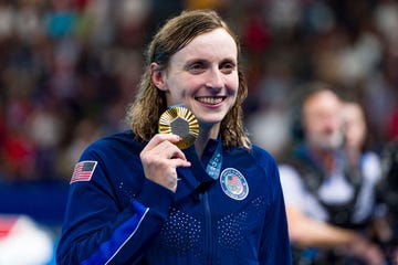 katie ledecky holds up a gold medal from the paris olympic games