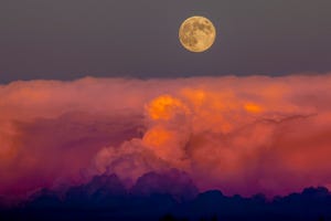 harvest moon rising above storm clouds, western colorado