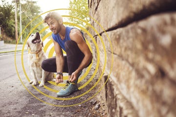 a person squatting down next to a dog in a tunnel