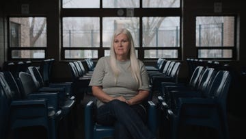 lois riess sitting in a chair and looking ahead in an empty room with giant windows