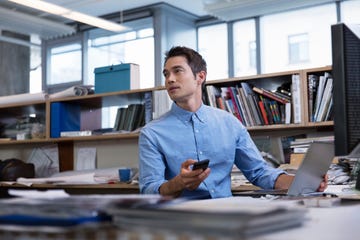 male professional in office holding technology