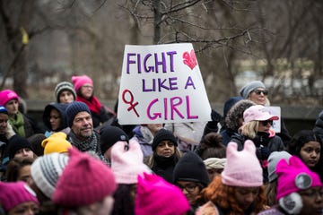 a protestor holds up a sign that says fight like a girl at the women's march in new york city