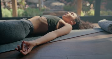 meditation, yoga and peace hand of black woman on pilates studio floor for fitness and wellness rest, zen and peace practice of a young person sleeping on the home gym ground for balance and chakra