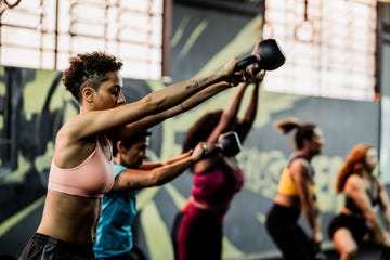 an adult woman trains with a kettlebell in the gym