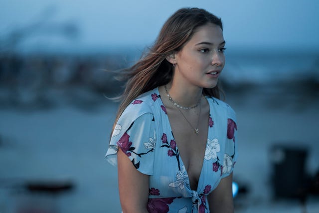 madelyn cline as sarah cameron in netflix's outer banks sitting by the docks and looking to the right