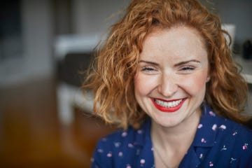 portrait of happy redheaded woman at home