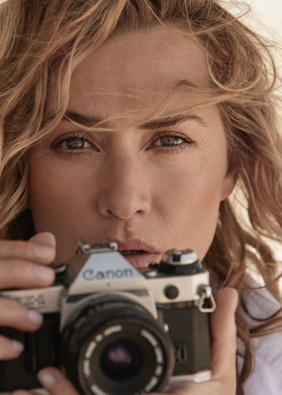 kate winslet holds a canon camera