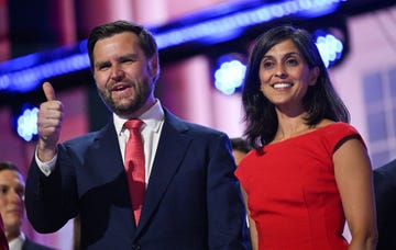 jd vance and usha vance stand together and smile, they wear formal attire