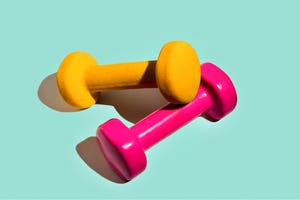 sport lifestyle concept with pink yellow dumbbells on pastel mint green background