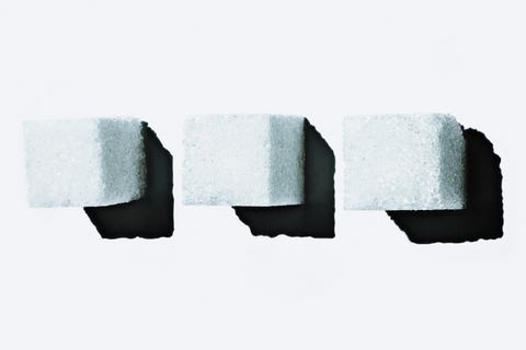 three sugar cubes positioned on a white background casting shadows