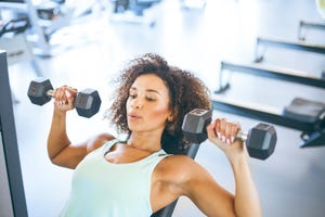 young woman weightraining at the gym