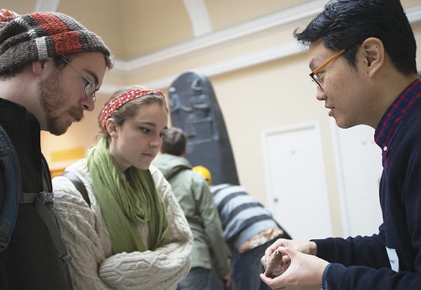 Man with object showing a man and a woman.