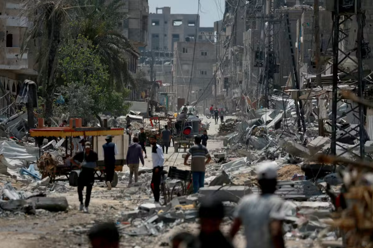 Palestinians walking amid the rubble of destroyed buildings