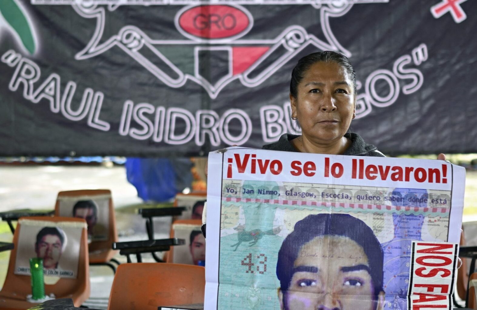 A woman holds a photo of a young man. Text reads: 