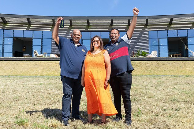 Across the county border, in Cornwall's Rock, Uttam Parmar, 58, from Leicestershire, won a luxury home with spectacular sea views in 2022. Pictured: Uttam Parmar, 58, (left), wife Raki, 53, and son Aaron, 26, in front of the £3million mansion