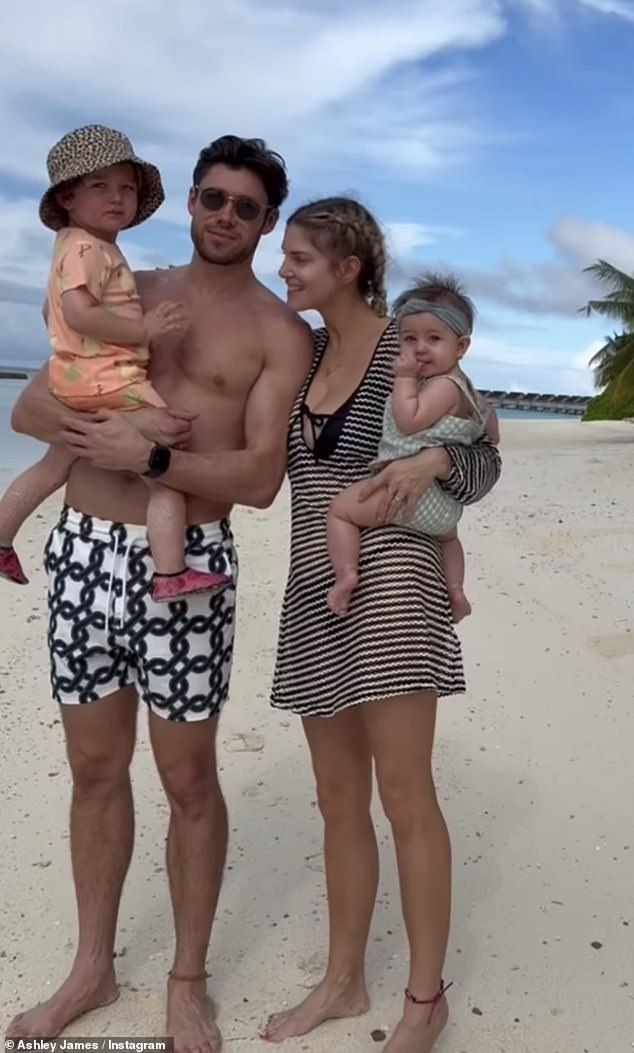 Cute: The family could be seen as they frolicked in the sand, with Ashley looking stylish in a stripe Kaftan from Beach Cafe