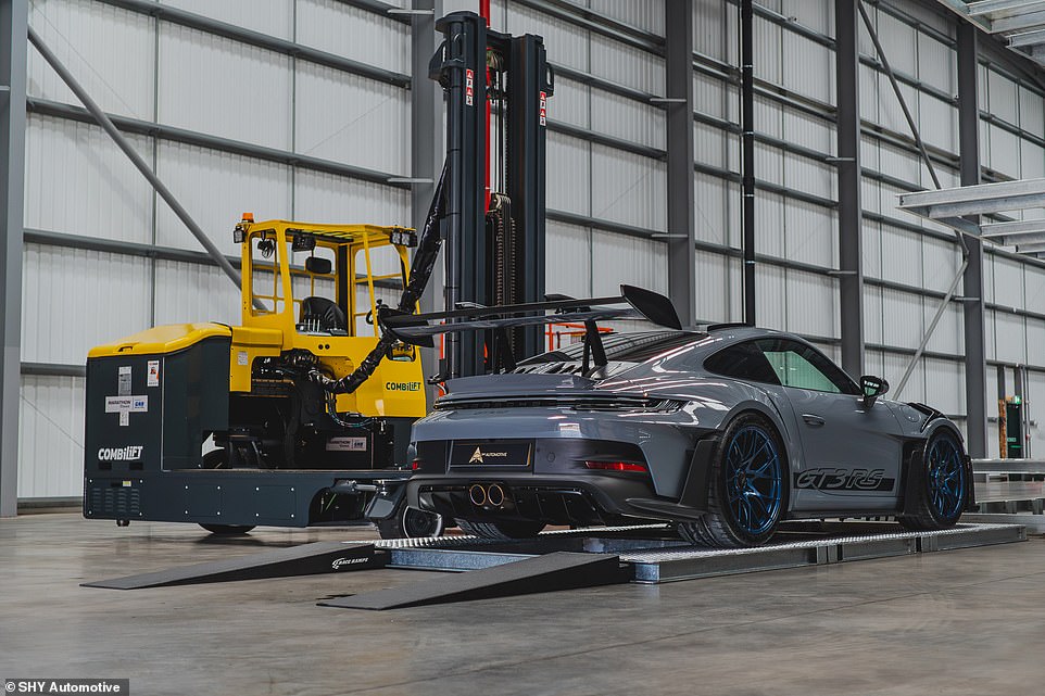 The cars - like this 911 GT3 RS - are first driven onto their own private bed before the forklift lifts them and slots them into their position, like a supercar vending machine