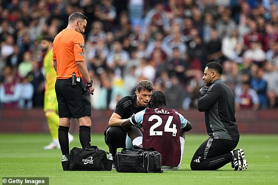 BIRMINGHAM, ENGLAND - AUGUST 24: Amadou Onana of Aston Villa is treated by the medical staff during the Premier League match between Aston Villa FC and Arsenal FC at Villa Park on August 24, 2024 in Birmingham, England. (Photo by Clive Mason/Getty Images)