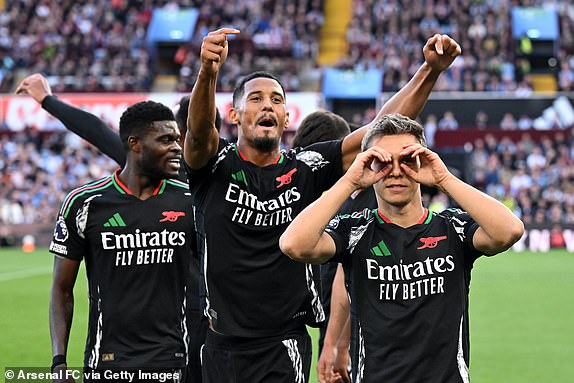 BIRMINGHAM, ENGLAND - AUGUST 24: Leandro Trossard of Arsenal celebrates scoring his team's first goal with teammate William Saliba during the Premier League match between Aston Villa FC and Arsenal FC at Villa Park on August 24, 2024 in Birmingham, England. (Photo by Stuart MacFarlane/Arsenal FC via Getty Images)