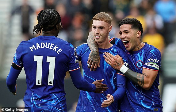 WOLVERHAMPTON, ENGLAND - AUGUST 25: Cole Palmer of Chelsea celebrates scoring his team's second goal with Noni Madueke and Enzo Fernandez during the Premier League match between Wolverhampton Wanderers FC and Chelsea FC at Molineux on August 25, 2024 in Wolverhampton, England. (Photo by David Rogers/Getty Images)