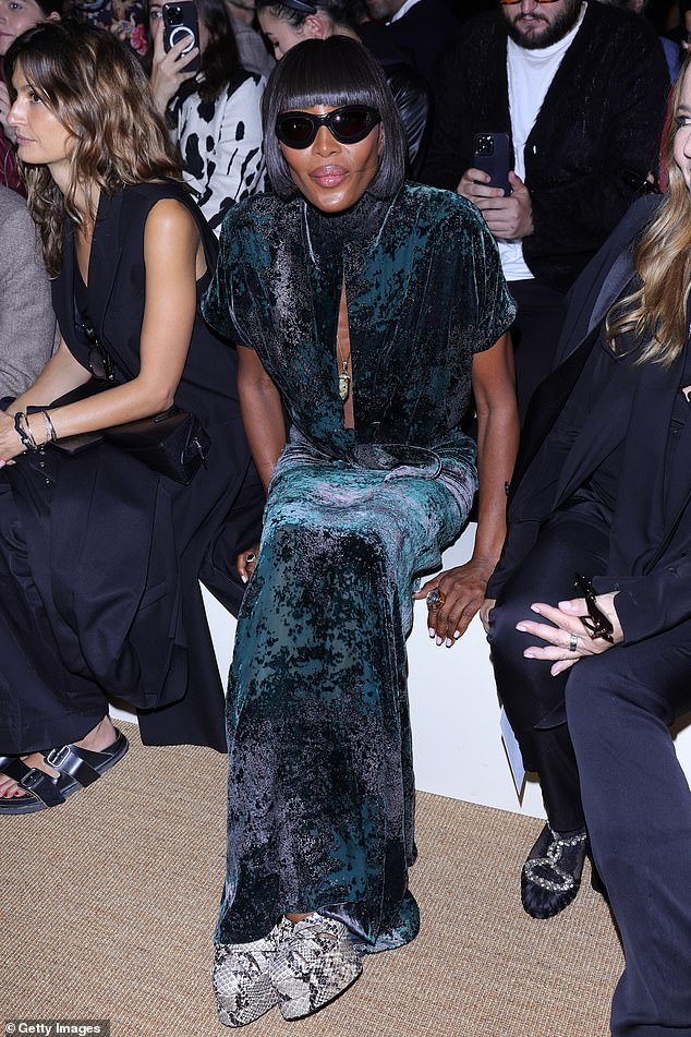 Naomi looked incredible in a green and black crushed velvet dress which she teamed with statement sunglasses and snakeskin print shoes