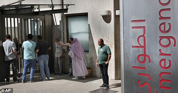 Families of victims who were injured Monday by their exploded handheld pagers, wait at the emergency entrance of the American University hospital, in Beirut, Lebanon, Wednesday, Sept. 18, 2024. (AP Photo/Hussein Malla)