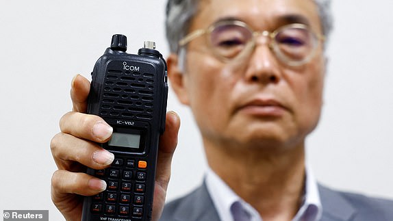 Japanese radio equipment maker Icom Inc director Yoshiki Enomoto shows its model IC-V82 device, which the company said they stopped production in 2014, during an interview at its headquarters  in Osaka, Japan, September 19, 2024. REUTERS/Kim Kyung-Hoon