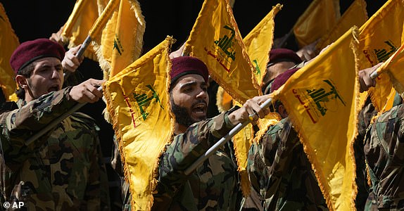 Hezbollah members attend the funeral of two of their comrades who were killed on Wednesday when a handheld device exploded, during a funeral procession in the southern suburbs of Beirut, Thursday, Sept. 19, 2024. (AP Photo/Hussein Malla)