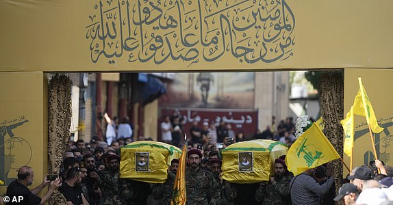 Hezbollah members carry the coffins of two of their comrades who were killed on Wednesday when a handheld device exploded, during a funeral procession in the southern suburbs of Beirut, Thursday, Sept. 19, 2024. (AP Photo/Hussein Malla)