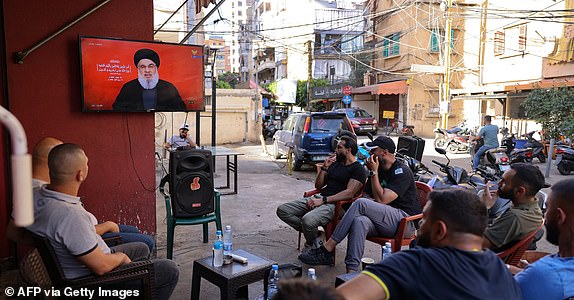 People watch on a television screen Hezbollah leader Hassan Nasrallah as he addresses the nation via video link, at a cafe in the Shiyah neighbourhood of Beirut's southern suburbs on September 19, 2024. Nasrallah said during his speech that Israel had dealt an "unprecedented" blow to his group, crossing all red lines with device explosions that killed 37 people and wounded nearly 3,000 over two days. (Photo by ANWAR AMRO / AFP) (Photo by ANWAR AMRO/AFP via Getty Images)