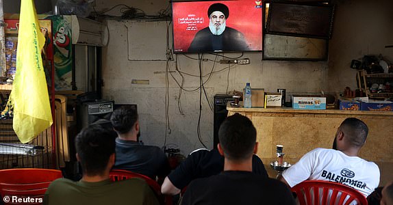 People watch Lebanon's Hezbollah leader Sayyed Hassan Nasrallah delivering a televised address, as they sit at a cafe in Sidon, Lebanon September 19, 2024. REUTERS/Aziz Taher