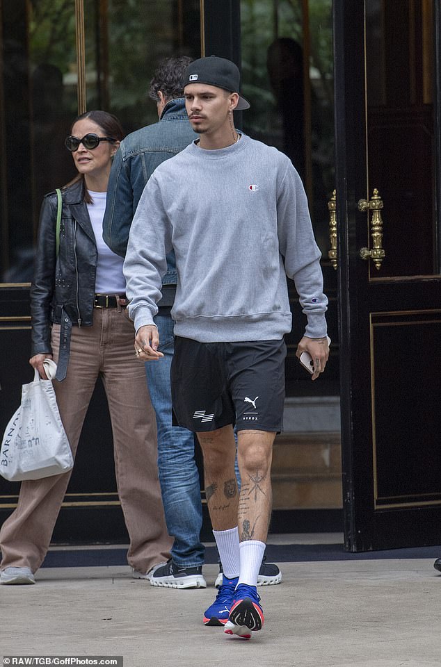 Showing off his tattooed legs, Romeo sported a pair of white ribbed socks and chunky violet trainers as he enjoyed a morning stroll