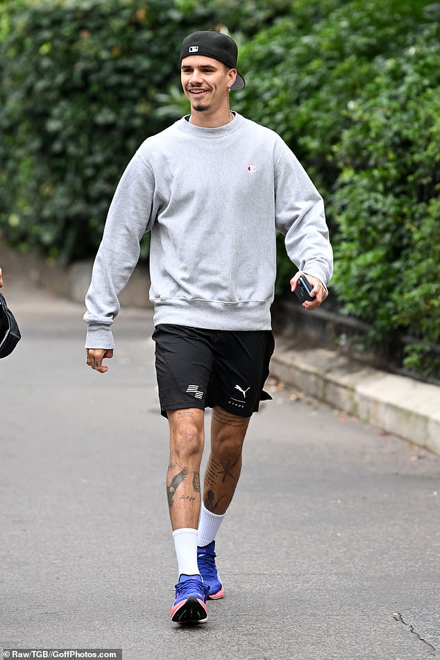 Romeo Beckham cut a casual figure in a grey Champion sweatshirt on Tuesday as he was pictured out and about during Paris Fashion Week