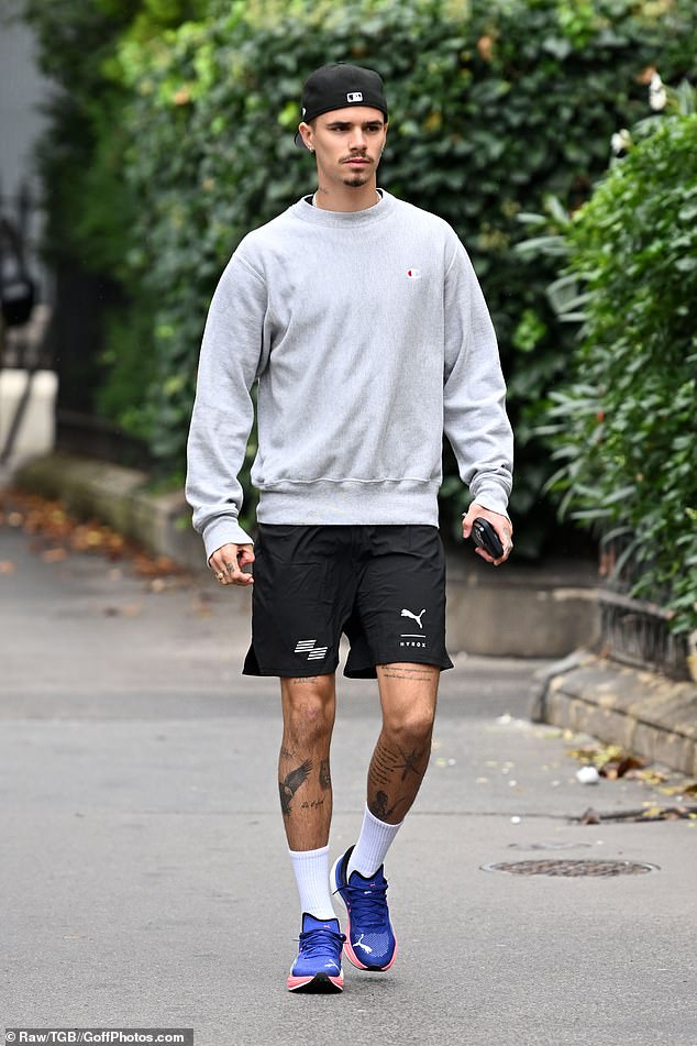 The footballer, 22, has arrived in the fashion capital with his mother Victoria, 50, who will showcase her eponymous clothing brand