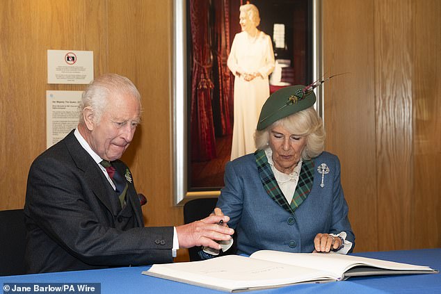 King Charles and Queen Camilla sign the visitors book following an event at the Scottish Parliament at Holyrood in Edinburgh