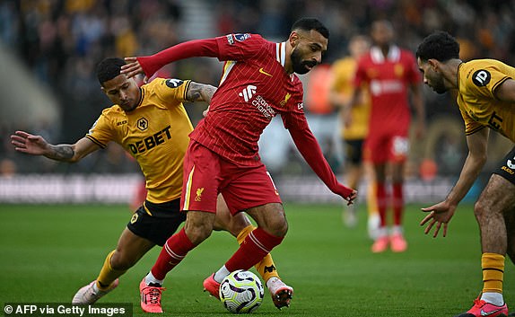 Wolverhampton Wanderers' Brazilian midfielder #08 Joao Gomes (L) vies with Liverpool's Egyptian striker #11 Mohamed Salah during the English Premier League football match between Wolverhampton Wanderers and Liverpool at the Molineux stadium in Wolverhampton, central England on September 28, 2024. (Photo by Paul ELLIS / AFP) / RESTRICTED TO EDITORIAL USE. No use with unauthorized audio, video, data, fixture lists, club/league logos or 'live' services. Online in-match use limited to 120 images. An additional 40 images may be used in extra time. No video emulation. Social media in-match use limited to 120 images. An additional 40 images may be used in extra time. No use in betting publications, games or single club/league/player publications. /  (Photo by PAUL ELLIS/AFP via Getty Images)