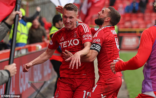 Skipper Graeme Shinnie helps Croatian new boy Palaversa celebrate his dramatic intervention