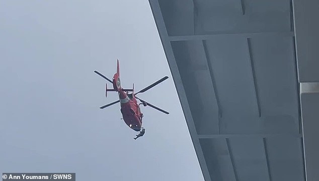 Stunning footage of the helicopter rescue shows people being winched into the craft as it hovers above the waiting ship