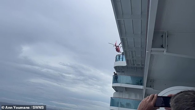 Lines of anxious passengers can be seen crowding the deck as they watch on, while the coast of Florida can be seen on the horizon, shrouded by storm clouds