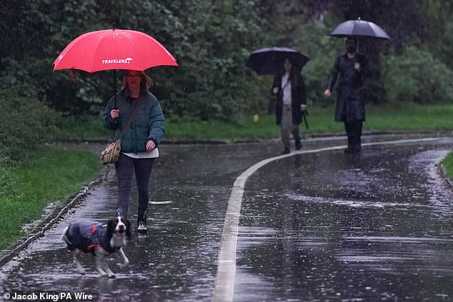 People use umbrellas as they walk during a rain shower in Warwick yesterday