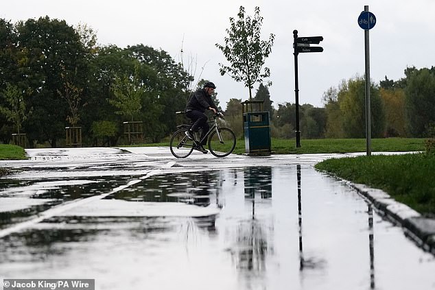 A cyclist passes puddles during a rain shower in Warwick after rainy weather swept across the country