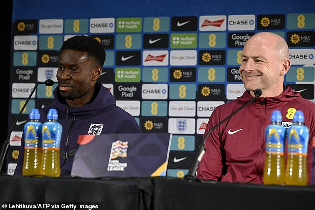 Guehi pictured sitting alongside England interim manager Lee Carsley (right) on Saturday